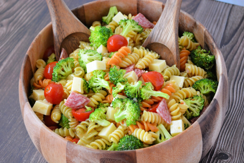 tender rotini noodles coated in Italian dressing with added broccoli, salama, mozzarella, and tomatoes