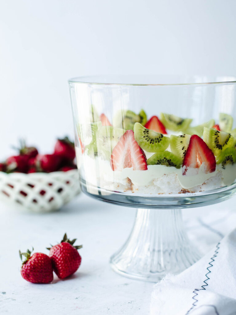 a side view of strawberries and kiwi in a glass dish.