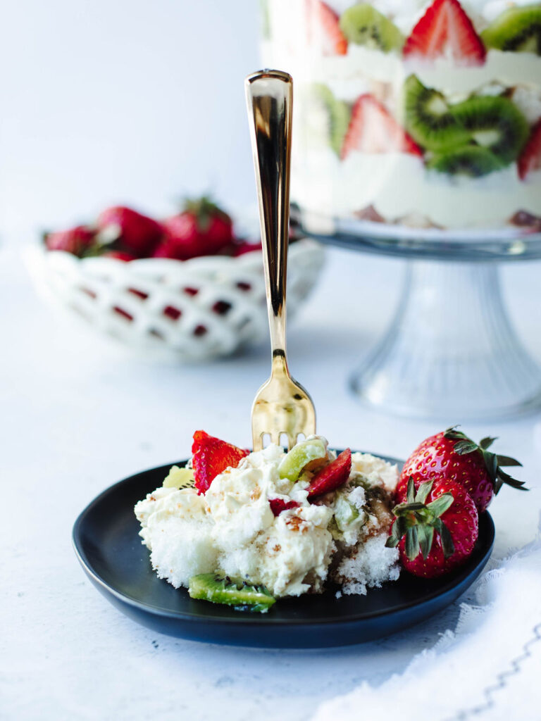 a serving of cake with fruit, pudding, and cool whip on a plate.