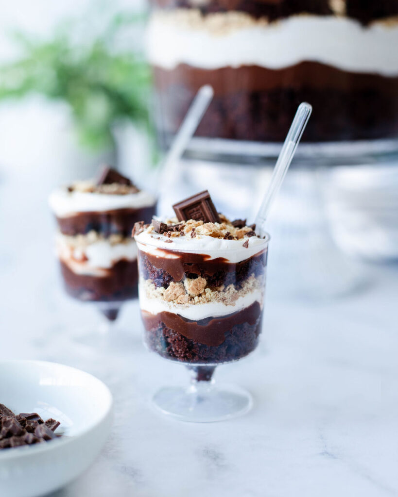 mini glass dishes with layers of chocolate pudding, graham crackers, and cake.