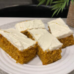 pumpkin cake cut into bars and topped with cream cheese frosting
