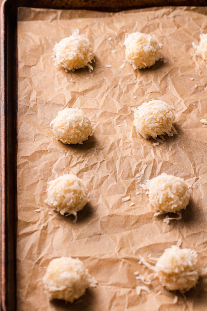macaroon cookie dough rolled out into balls on a cookie sheet