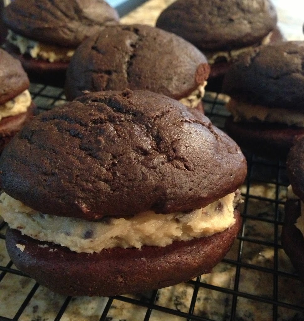 creamy cookie dough sandwiches between two chocolate cake cookies