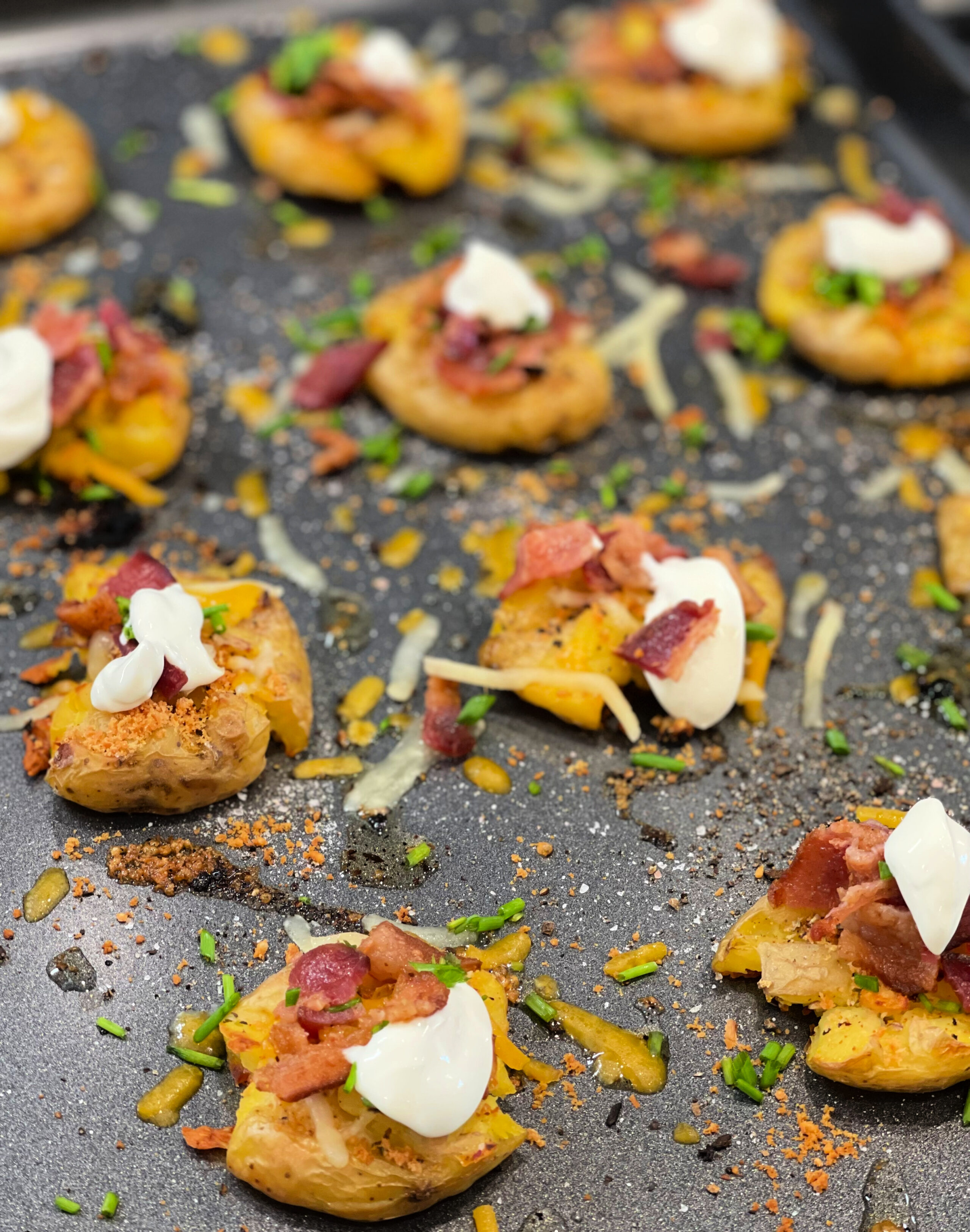 loaded smashed potatoes on a baking sheet.