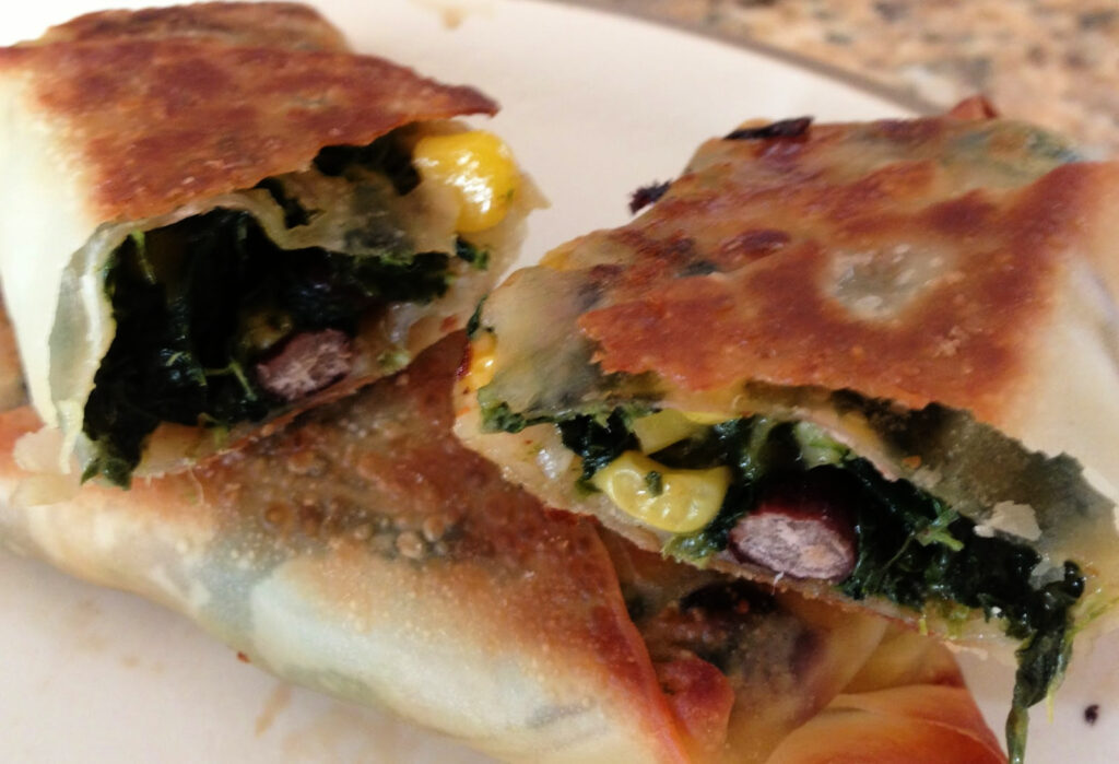 baked egg rolls with a black bean spinach mixture inside