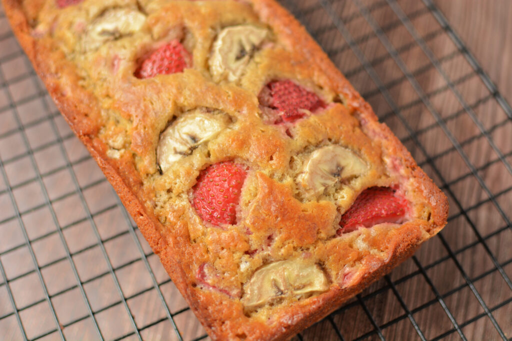 baked banana bread with bits of strawberry throughout