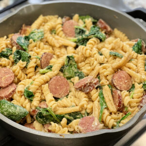 cajun seasoned alfredo pasta with spinach and sausage slices throughout