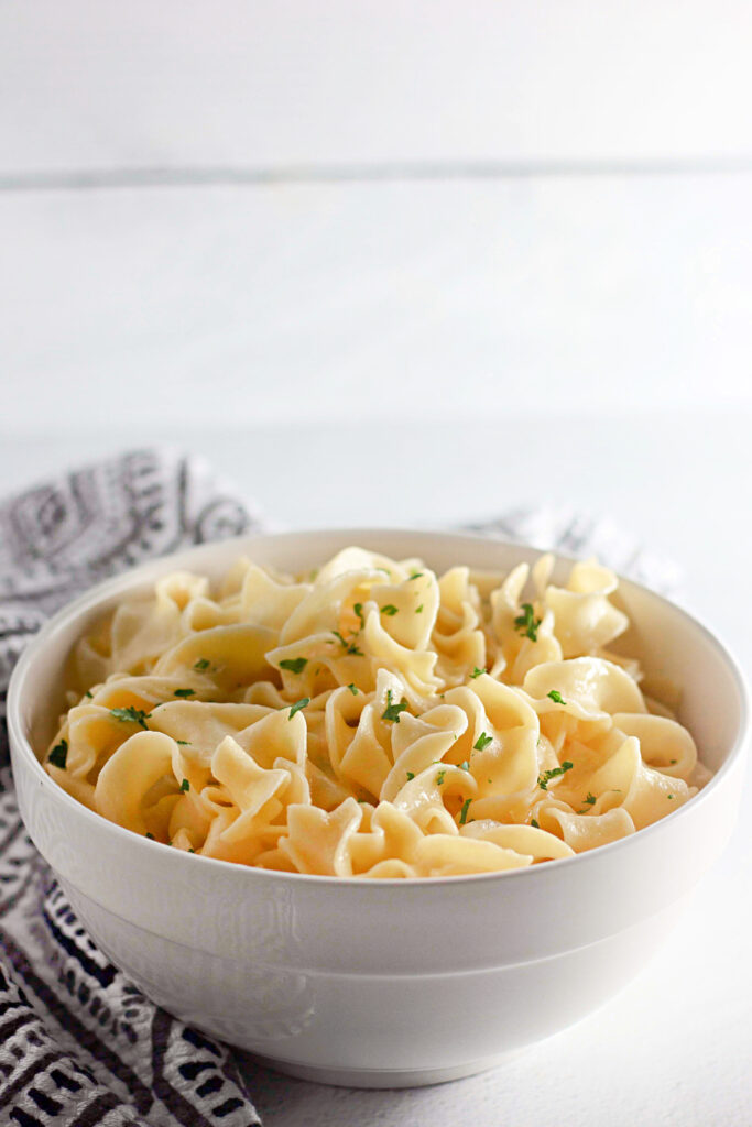 a white dinner bowl with tender pasta inside.