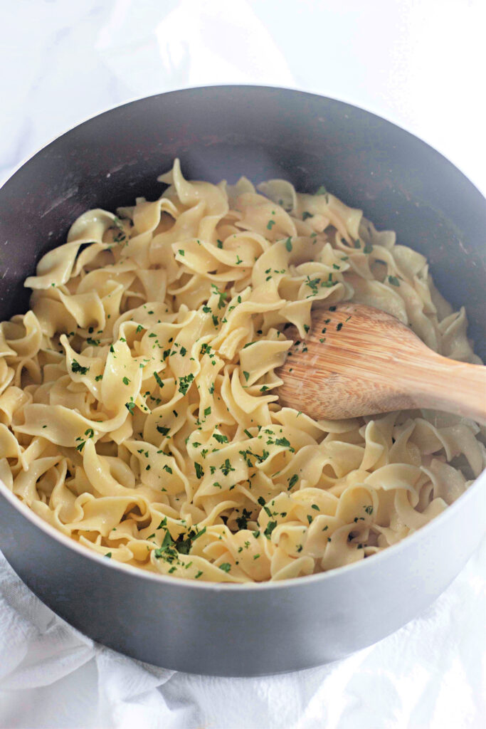 a cooking pot with buttered pasta ready to be served.
