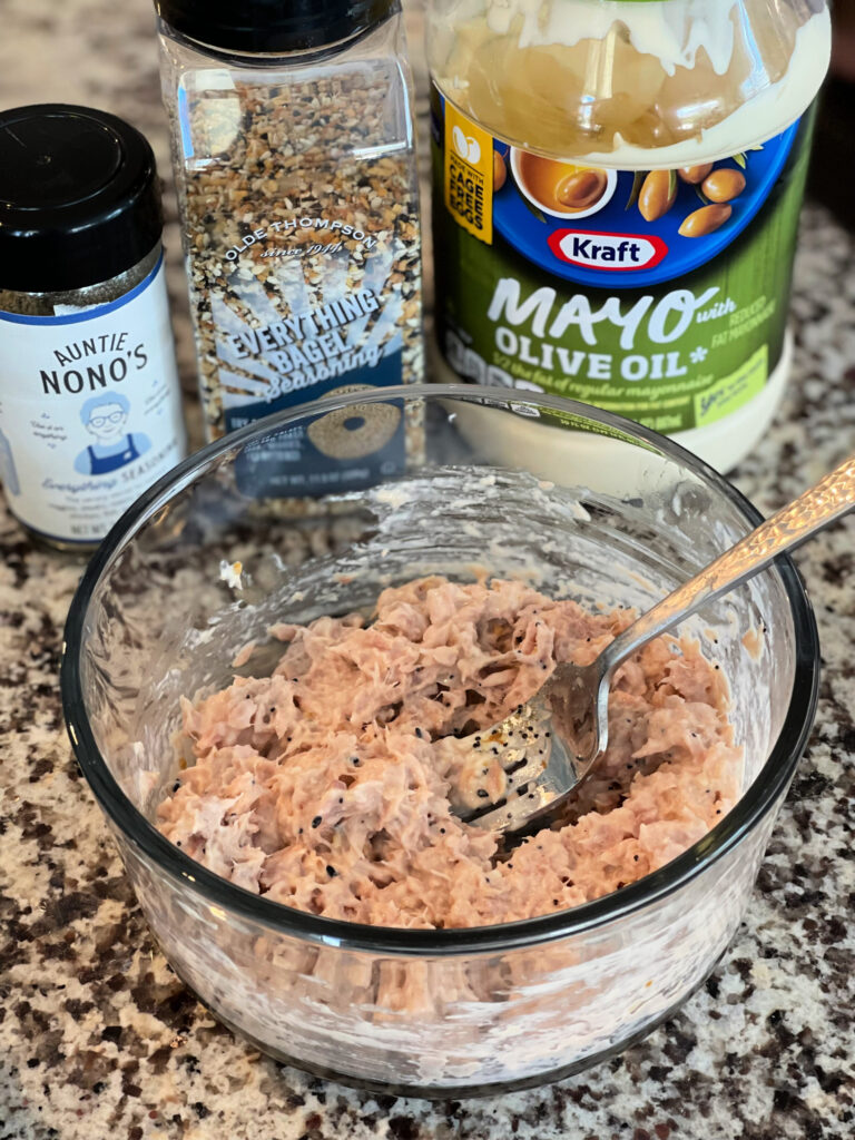 tuna combined with mayonnaise, seasonings, and more in a bowl