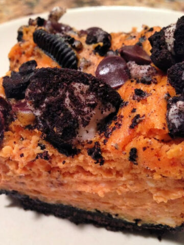 pumpkin cheesecake over an oreo crust cut into bars