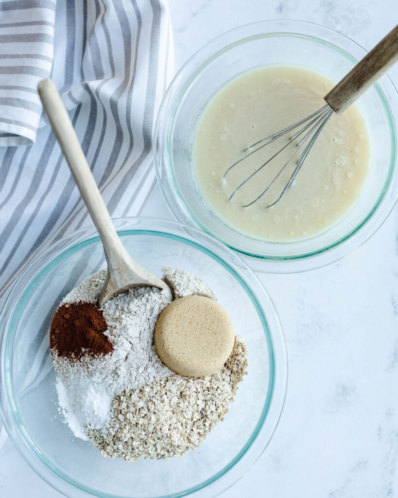 the wet ingredients and dry ingredients in mixing bowls for a muffin recipe.