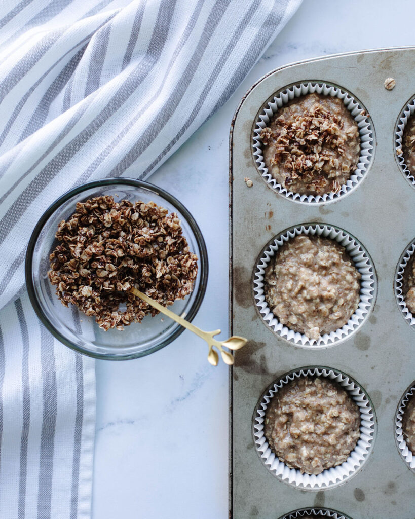 oat topping being sprinkled over batter in a greased tin.
