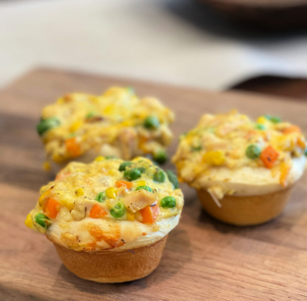 biscuits baked in a muffin cup with chicken, vegetables, and gravy mixture to make mini chicken pot pies