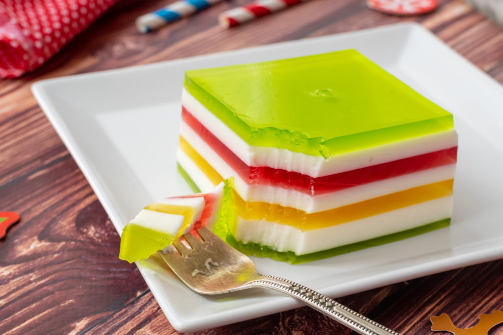 colorful layers of jello combined into one dish for a layered christmas dish