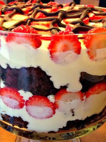 layers of brownies, Instant vanilla pudding, cool whip, and fresh strawberries combined in a glass trifle bowl.