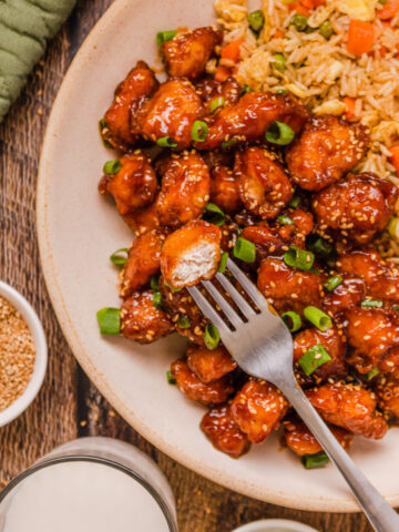 a plate of honey sesame chicken with fried rice