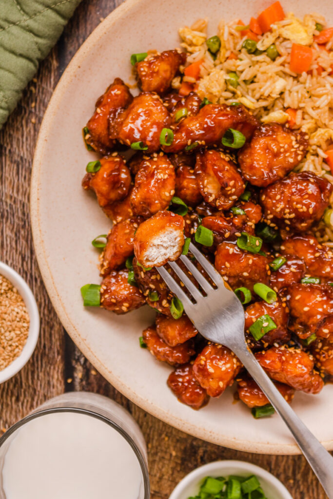 a plate of honey sesame chicken with fried rice