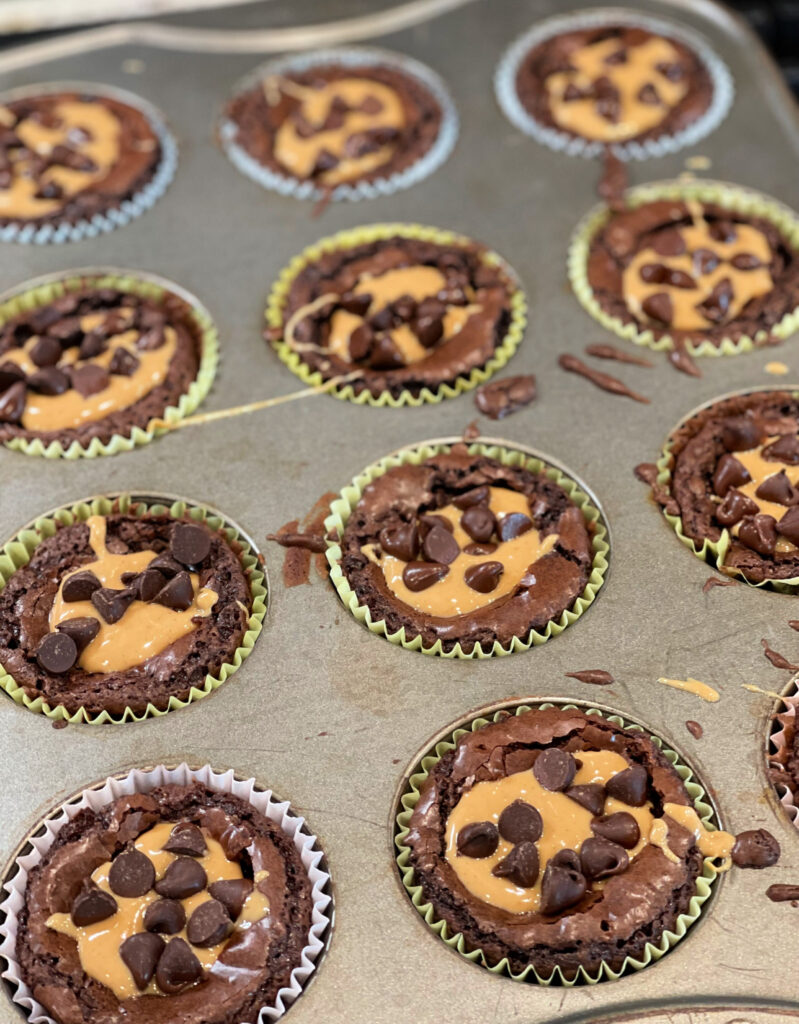 bize sized brownie cups with peanut butter and chocolate chips on top