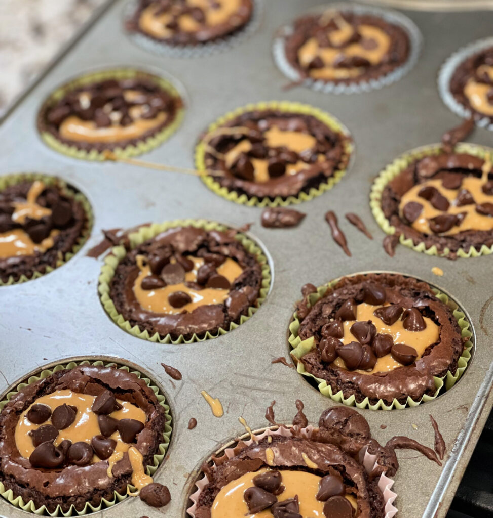 mini chocolate brownie cups with creamy peanut butter and chocolate chips on top
