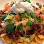Frito Pie with sour cream and tomatoes