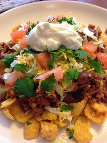 Frito Pie with sour cream and tomatoes