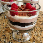 a mini tiramisu trifle consisting of layers of cookie crumbs, whipped topping, and a coffee mixture