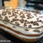 layered chocolate chip cookie with pudding, cool whip and a cream chese layer