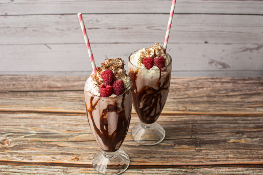 creamy ice cream blended with chocolate and raspberries in a milkshake mug.