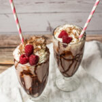 ice cream, milk, chocolate, and raspberries blended into a shake and served in glasses.