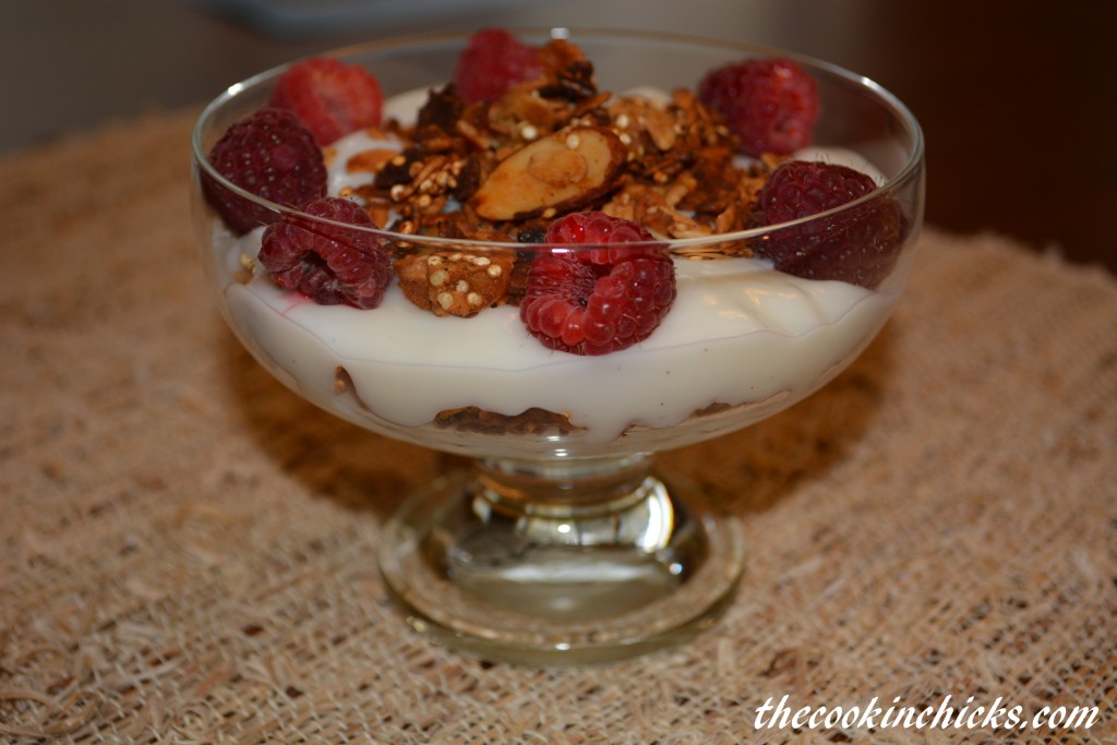 apple spice granola combined with yogurt and raspberries in a parfait