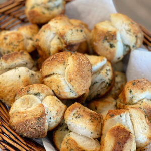 mini garlic bread muffins made using pre-made biscuit dough and coating it in butter and garlic