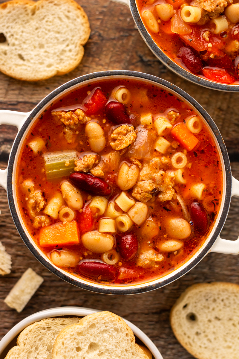 a white soup bowl of pasta e fagioli with pasta or Italian sausage.