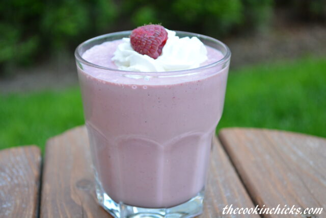 Chocolate Raspberry Milkshake in a small, clear glass topped with whipped cream and a rasberry