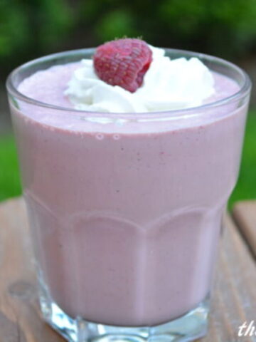 Chocolate Raspberry Milkshake in a small, clear glass topped with whipped cream and a rasberry