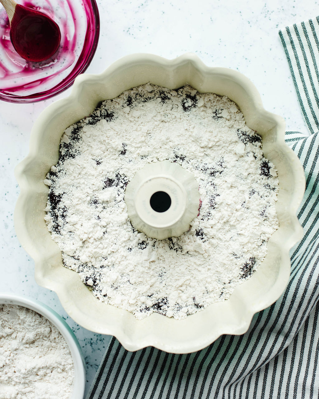 Bisquick sprinkled over blueberry pie filling in a bundt pan.