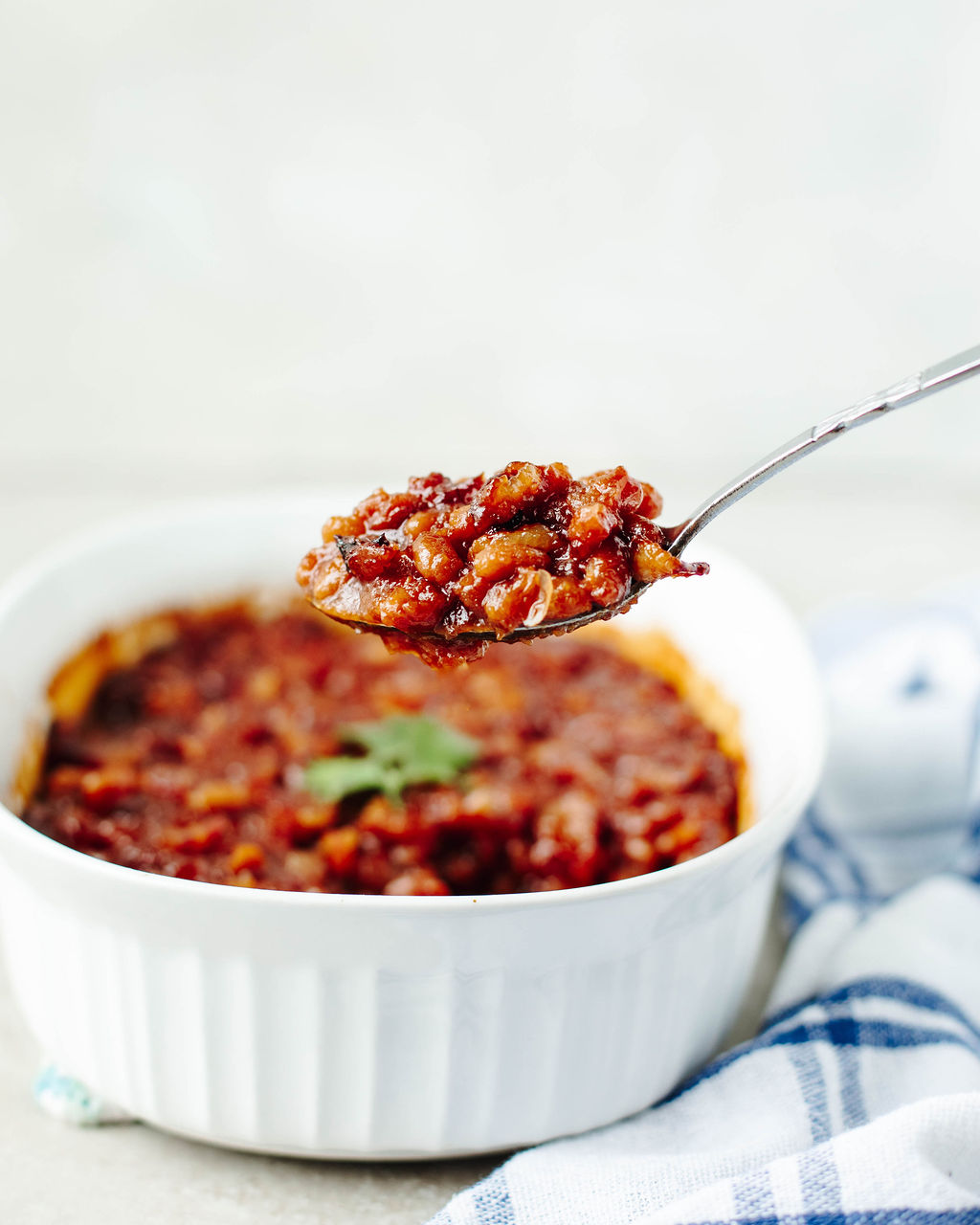 a spoonful of beans ready to serve from a casserole dish.
