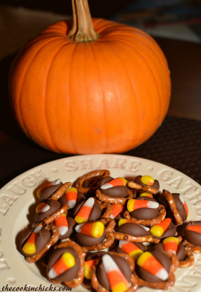 bite sized halloween treats made with pretzels, hershey kisses, and candy corn