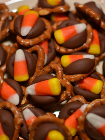 candy corn and hershey kisses melted on top of pretzels