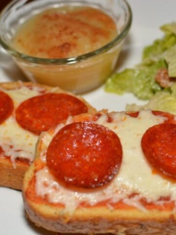 garlic buttery toast with pizza toppings added to create a mini pizza