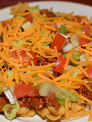 layers of chips, beef, cheese, and toppings combine into a flavorful tex mex dish