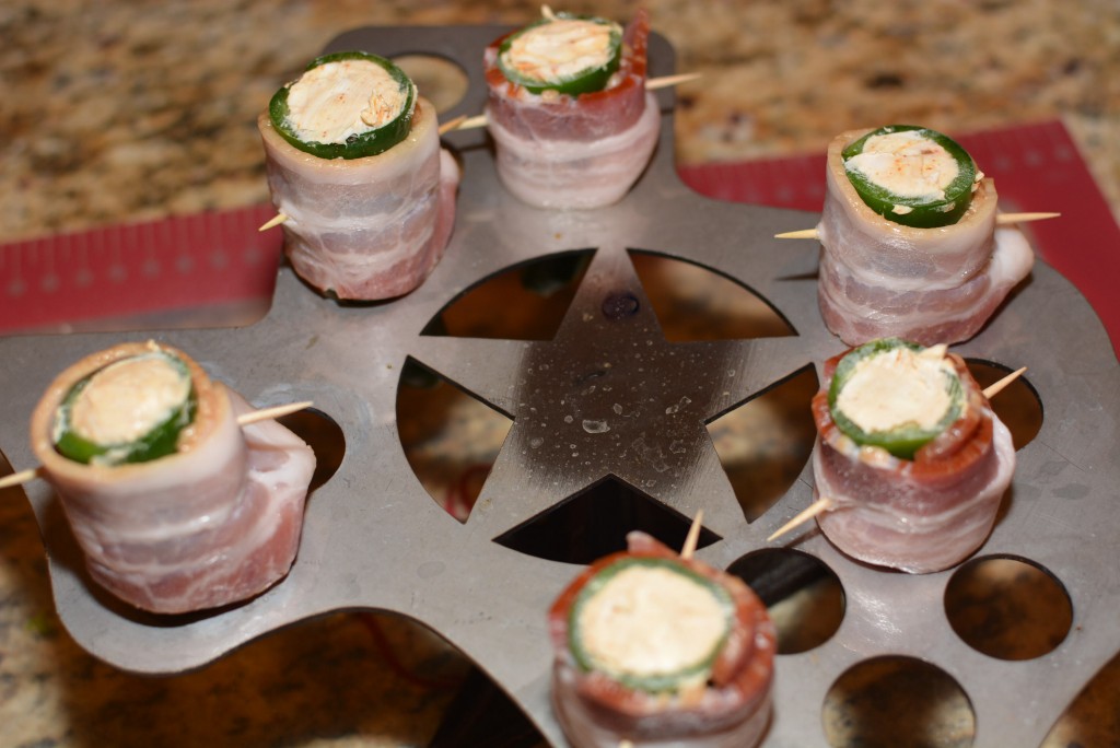 goat cheese stuffed jalapenos with a slice of bacon wrapped on the outside