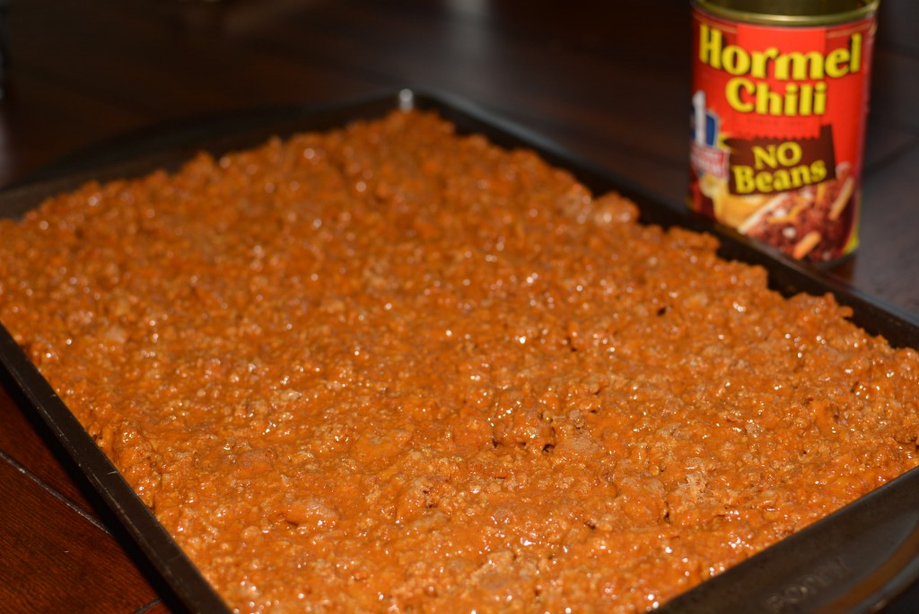 seasoned meat combined with chili and cheese and spread into a cookie sheet pan