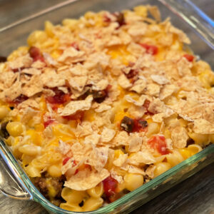 macaroni and cheese combined with taco seasoned ground beef, cheese, tortilla chips, and salsa