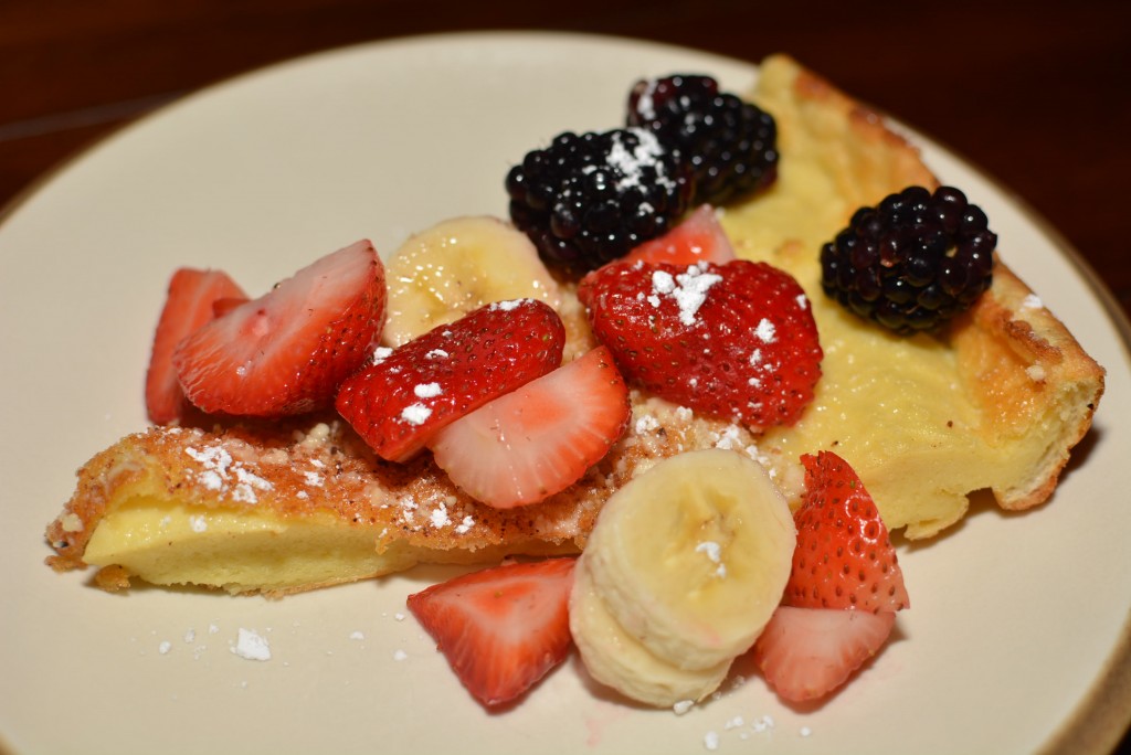 fluffy pancakes topped with fresh fruit and powdered sugar