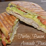 layers of turkey, avocado, and bacon combined into a panini