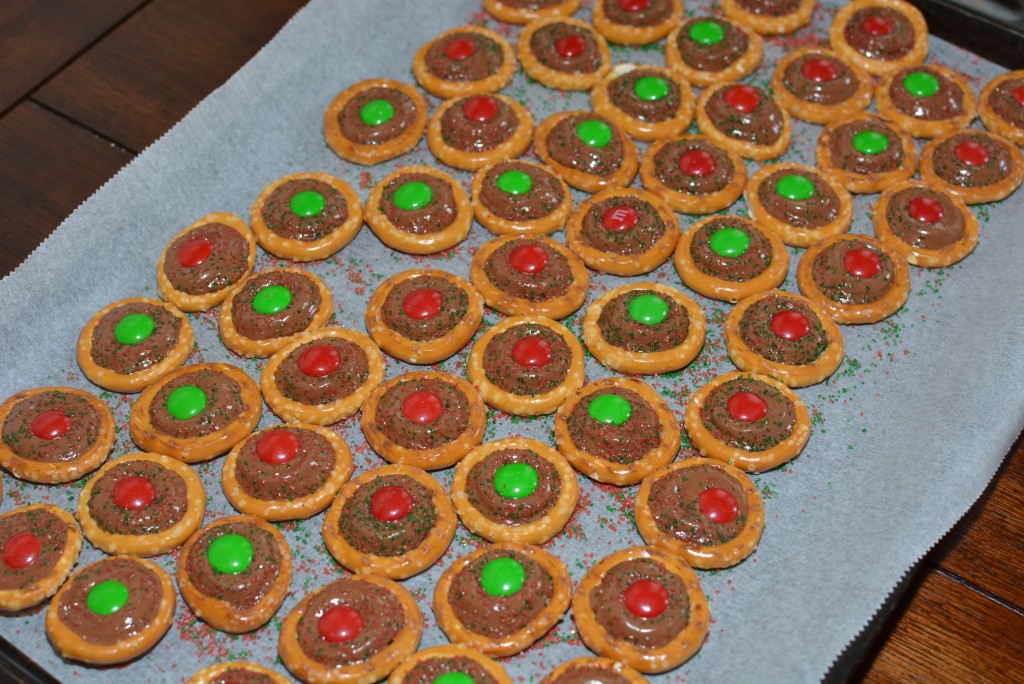 rolo pretzel treats have a melted rolo in the center of a pretzel with an m&m on top