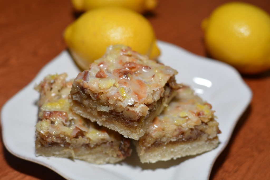 lemon dream bars consisting of a melt in your mouth crust, lemon filling, and nut topping