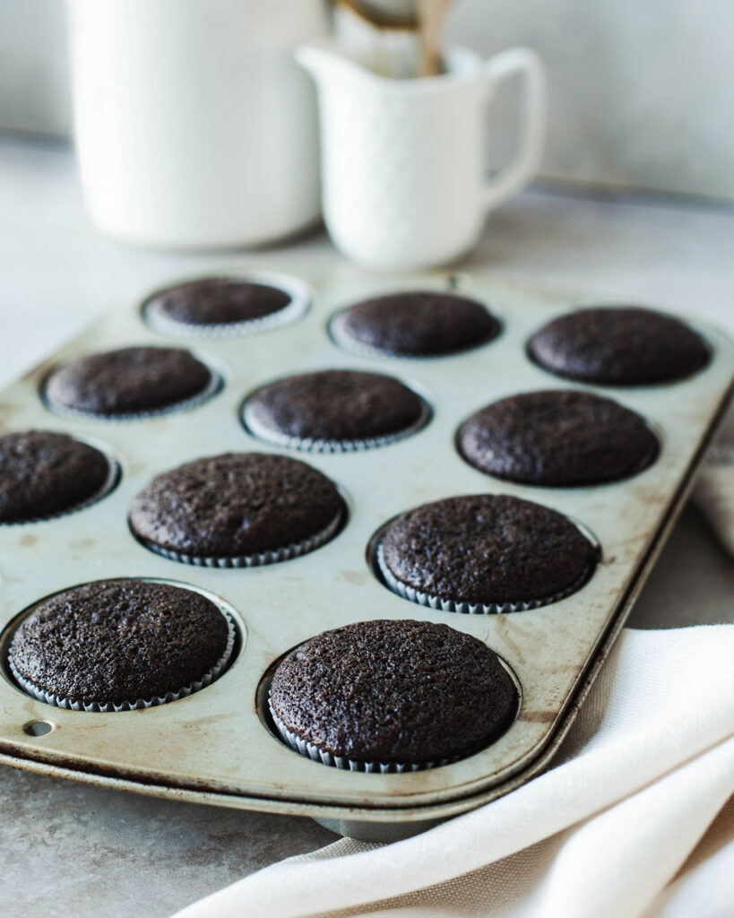 a muffin pan filled with baked chocolate cupcakes.