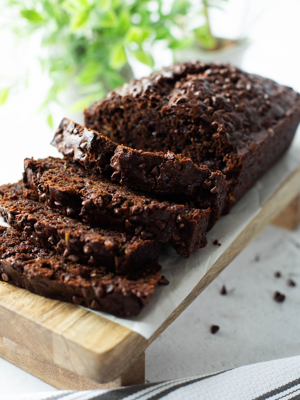 a loaf of chocolate zucchini bread sliced on a cutting board.